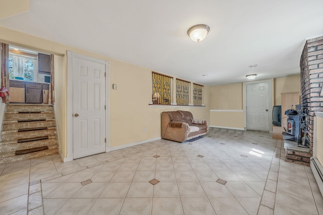 unfurnished room with baseboards, baseboard heating, and stairs