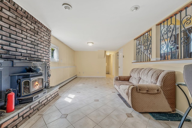 living room featuring light tile patterned floors, baseboards, a wood stove, and a baseboard heating unit