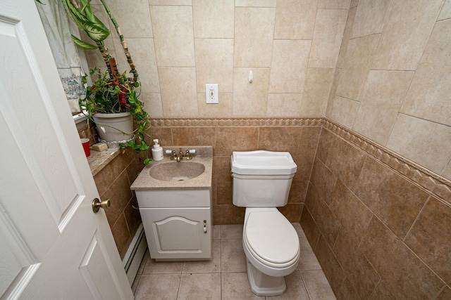 half bath with toilet, tile walls, baseboard heating, and tile patterned flooring