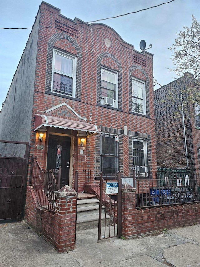 view of front facade featuring brick siding, cooling unit, and fence private yard