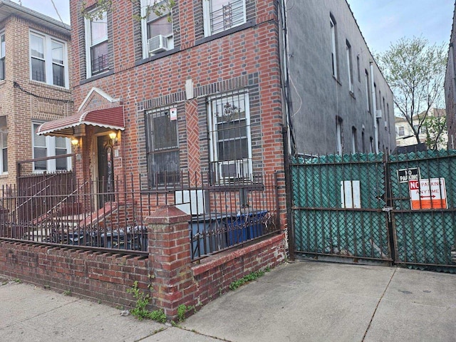 view of home's exterior featuring brick siding, fence, and cooling unit