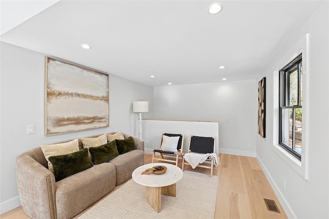 living area with light wood-style floors, baseboards, visible vents, and recessed lighting