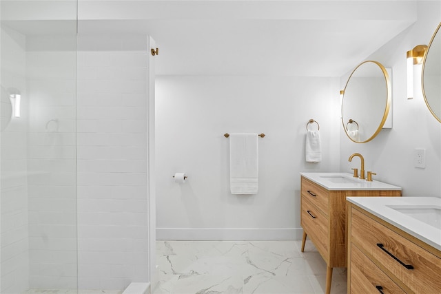 full bathroom with a sink, marble finish floor, a walk in shower, two vanities, and baseboards