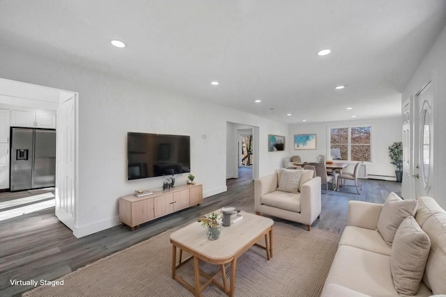 living area with recessed lighting, a baseboard heating unit, baseboards, and wood finished floors