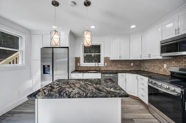 kitchen with appliances with stainless steel finishes, tasteful backsplash, a sink, white cabinets, and recessed lighting