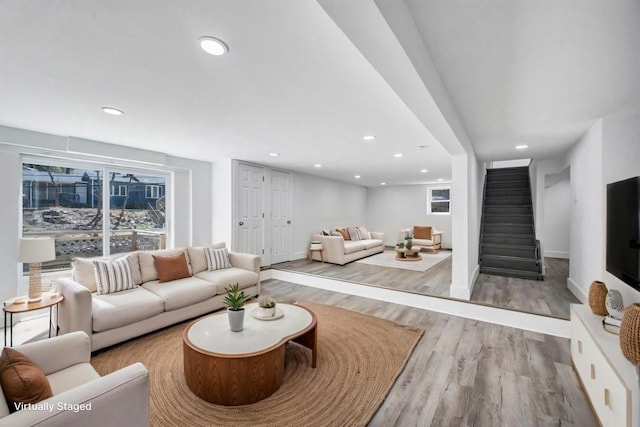 living room with stairs, recessed lighting, and wood finished floors