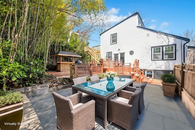 view of patio / terrace featuring a wooden deck, stairway, and outdoor dining space