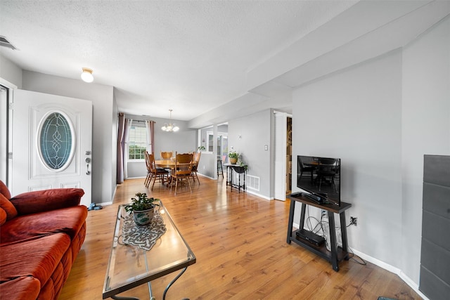 2816 Whispering Hls, Chester, NY 10918 - living area featuring a chandelier, light wood finished floors, a textured ceiling, and baseboards
