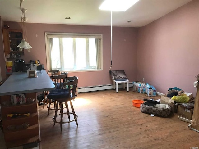 playroom featuring wood finished floors and a baseboard radiator