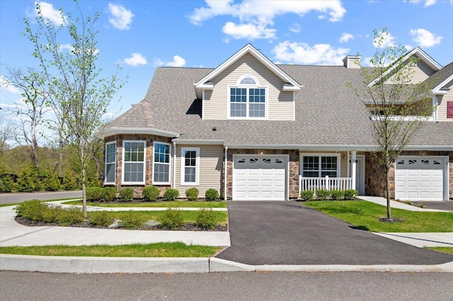 view of front of home with aphalt driveway, covered porch, stone siding, a shingled roof, and an attached garage