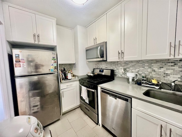 39-60 54th St Unit 7U, Woodside, NY 11377 - kitchen with tasteful backsplash, white cabinets, and appliances with stainless steel finishes