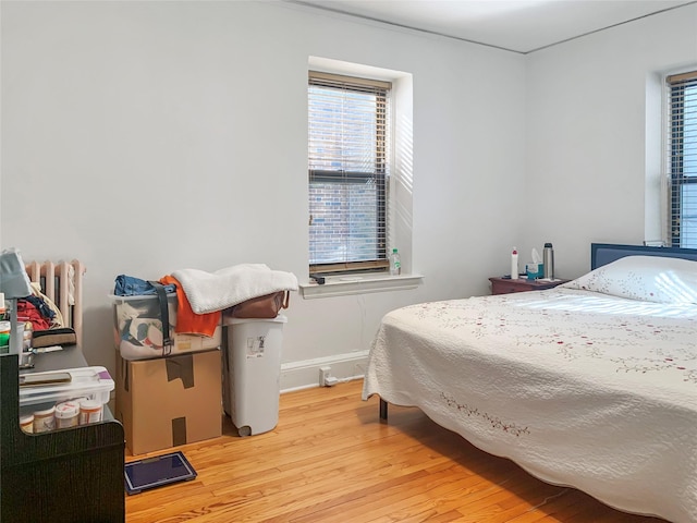 bedroom featuring light wood-style floors and baseboards