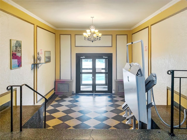 foyer with a textured wall, an inviting chandelier, ornamental molding, and french doors