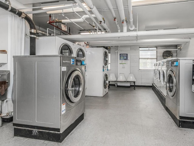community laundry room with light floors, washing machine and dryer, and stacked washer / dryer