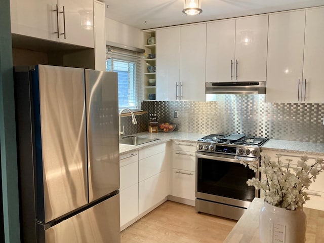 kitchen featuring open shelves, under cabinet range hood, white cabinets, a sink, and appliances with stainless steel finishes