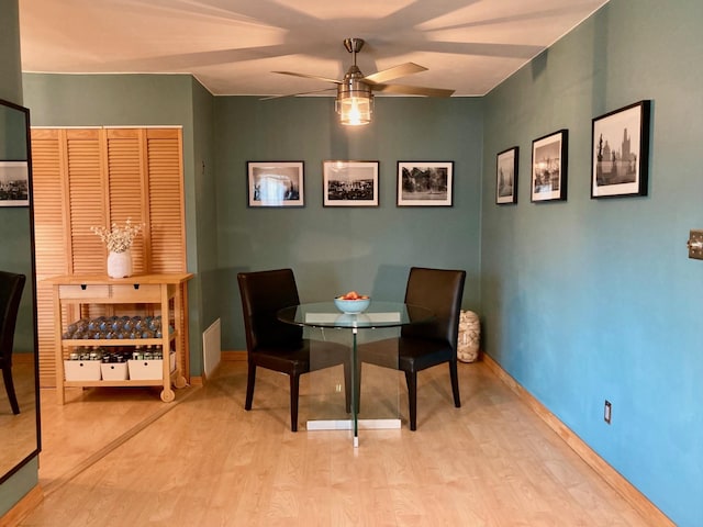 dining space with baseboards, ceiling fan, and wood finished floors