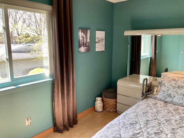 bedroom with baseboards and wood finished floors