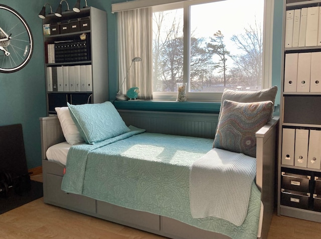 bedroom with multiple windows and wood finished floors