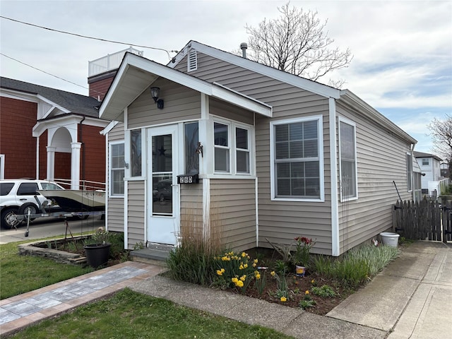 bungalow-style house with fence and entry steps