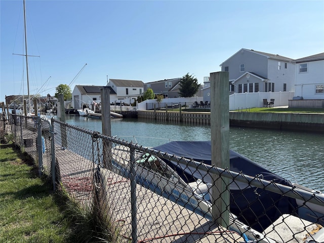 dock area featuring a residential view, fence, and a water view