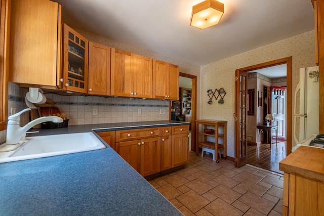11 Mcintosh Dr, Poughkeepsie, NY 12603 - kitchen with wallpapered walls, decorative backsplash, glass insert cabinets, and a sink