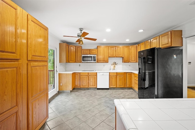 kitchen with black appliances, a ceiling fan, tasteful backsplash, ornamental molding, and light countertops
