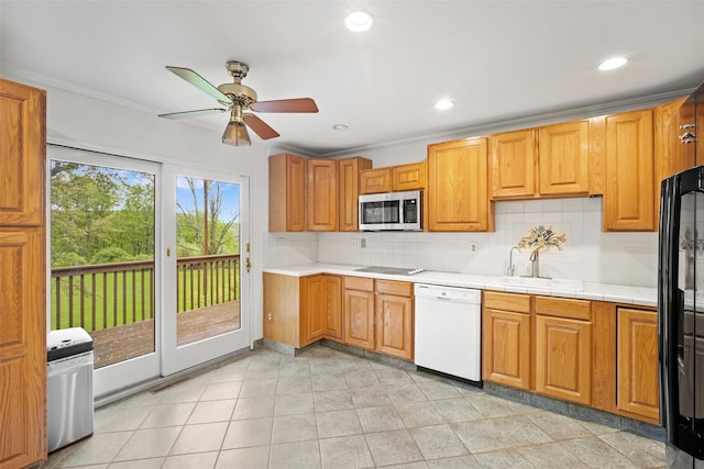 kitchen with dishwasher, a sink, stainless steel microwave, a ceiling fan, and backsplash
