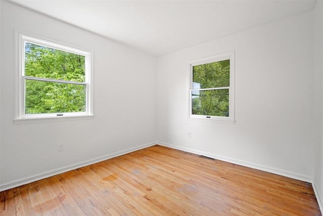 unfurnished room featuring light wood-type flooring and baseboards