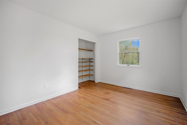 spare room with light wood finished floors and baseboards
