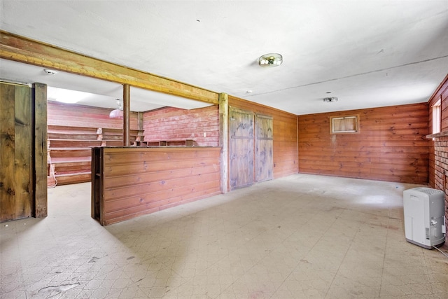 spare room with tile patterned floors and wood walls