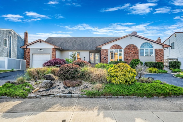 3452 Ocean Ave, Oceanside, NY 11572 - view of front of home featuring brick siding, an attached garage, asphalt driveway, and fence