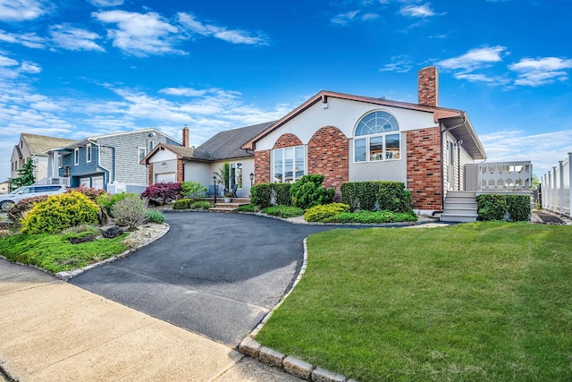 3452 Ocean Ave, Oceanside, NY 11572 - view of front facade featuring a chimney, asphalt driveway, a front lawn, and brick siding
