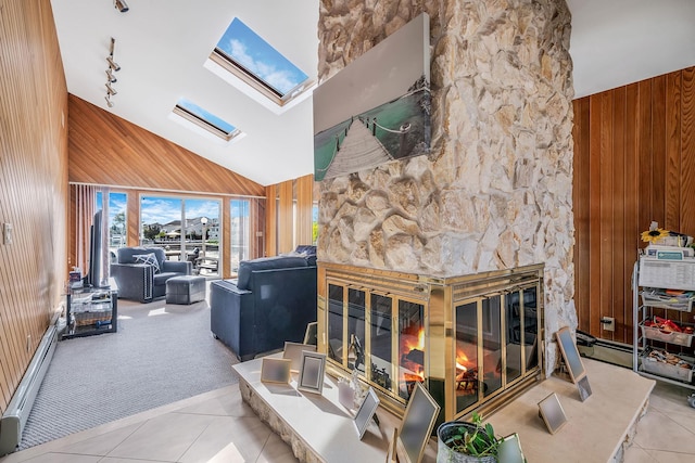 3452 Ocean Ave, Oceanside, NY 11572 - carpeted living room with wooden walls, a skylight, a stone fireplace, high vaulted ceiling, and tile patterned flooring
