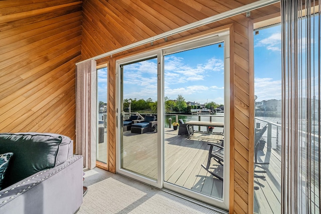 3452 Ocean Ave, Oceanside, NY 11572 - doorway with wood walls, healthy amount of natural light, a water view, and carpet