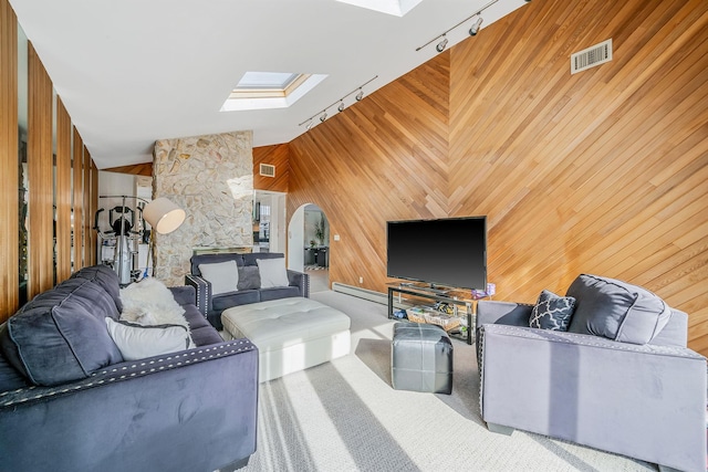 3452 Ocean Ave, Oceanside, NY 11572 - living area featuring a skylight, rail lighting, a baseboard radiator, wood walls, and carpet