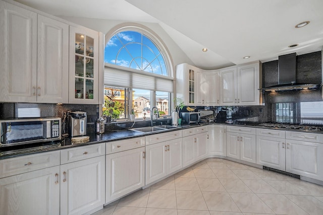 3452 Ocean Ave, Oceanside, NY 11572 - kitchen with stainless steel microwave, a sink, vaulted ceiling, wall chimney range hood, and dark countertops