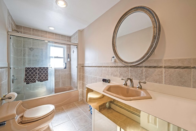 3452 Ocean Ave, Oceanside, NY 11572 - bathroom featuring a sink, tile walls, toilet, shower / bath combination with glass door, and tile patterned flooring