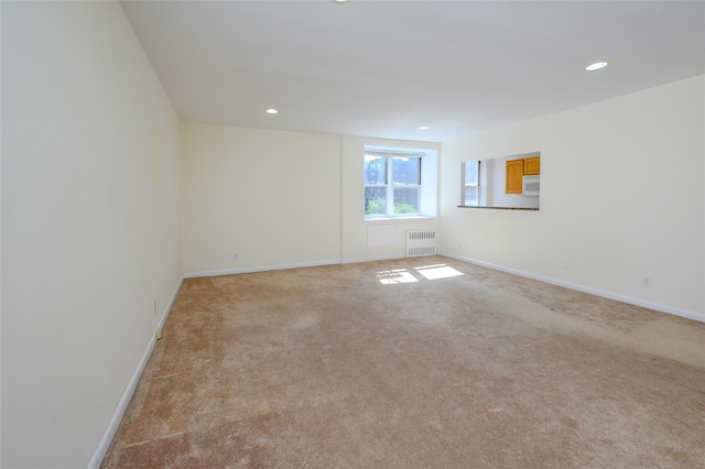 4 Sadore Ln Unit 3M, Yonkers, NY 10710 - spare room with radiator, light carpet, baseboards, and recessed lighting