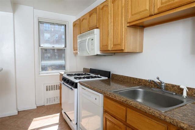 4 Sadore Ln Unit 3M, Yonkers, NY 10710 - kitchen with a sink, radiator, white appliances, dark countertops, and light tile patterned flooring