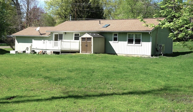 10 Aspinwall Rd, Red Hook, NY 12571 - rear view of property featuring roof with shingles, a lawn, a wooden deck, an outdoor structure, and a shed