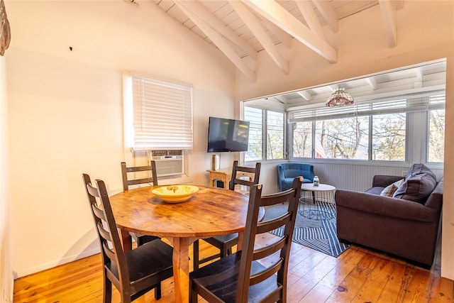 dining space with vaulted ceiling with beams, cooling unit, and hardwood / wood-style flooring