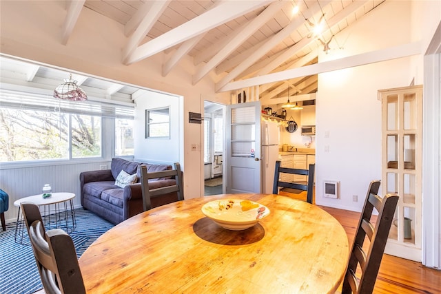 dining space featuring lofted ceiling with beams, wooden ceiling, and light wood-type flooring