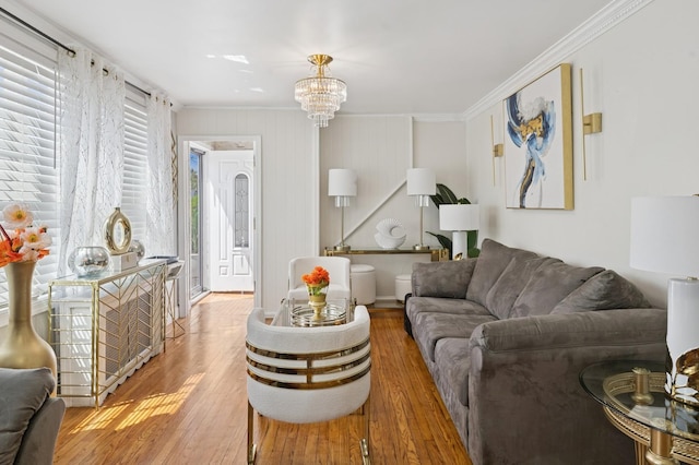 living area featuring crown molding, wood finished floors, and an inviting chandelier