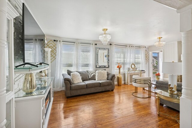 living area featuring crown molding, a chandelier, and hardwood / wood-style floors