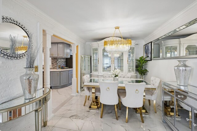 dining space with crown molding, marble finish floor, and a notable chandelier