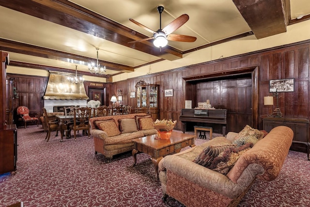 living area featuring carpet flooring, ceiling fan with notable chandelier, beam ceiling, and wooden walls