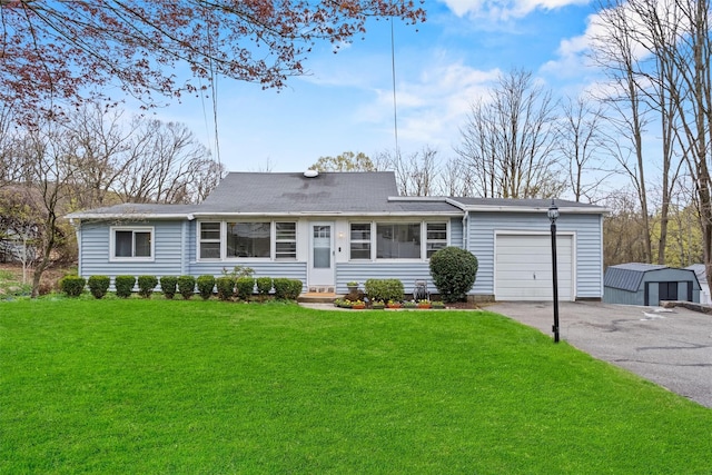 ranch-style home featuring aphalt driveway, a garage, entry steps, roof with shingles, and a front lawn