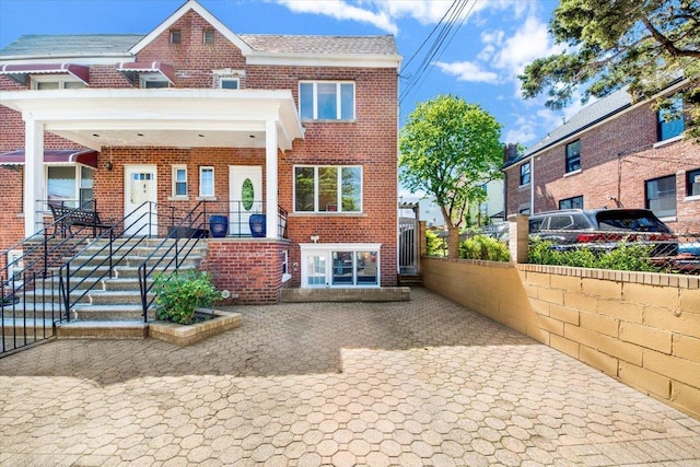 view of front of house featuring fence and brick siding