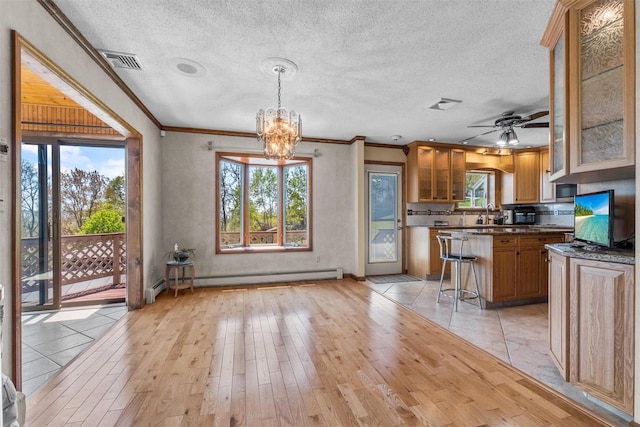 kitchen with visible vents, light wood finished floors, crown molding, and baseboard heating
