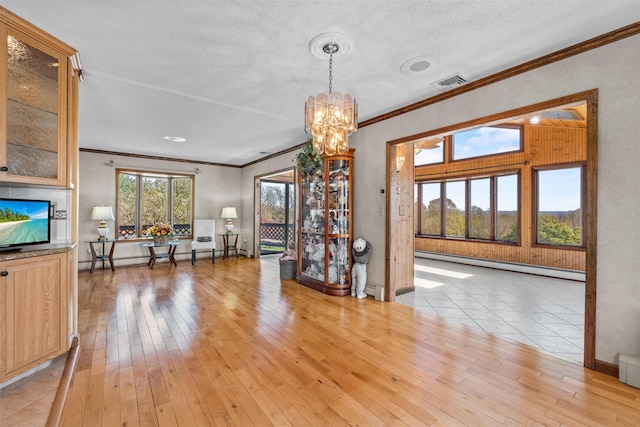 dining space with an inviting chandelier, crown molding, baseboard heating, and visible vents